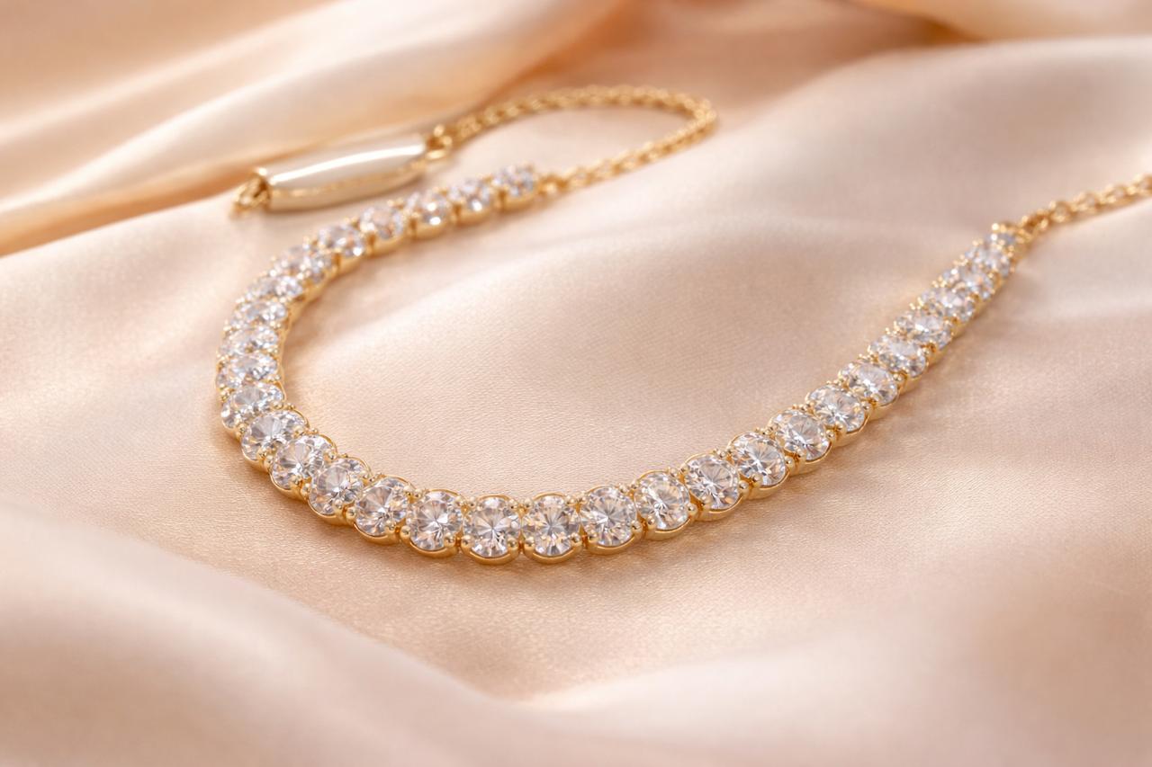 Minimal diamond necklace in gold with round-cut stones on soft satin background